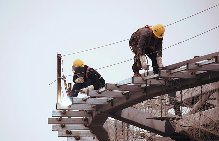 Two construction workers working on a high rise building.jpg