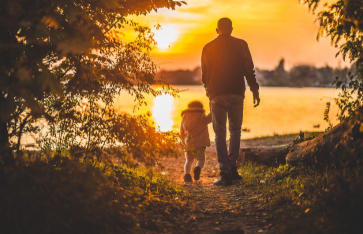 Parent Holding Childs Hand On A Walk In Nature