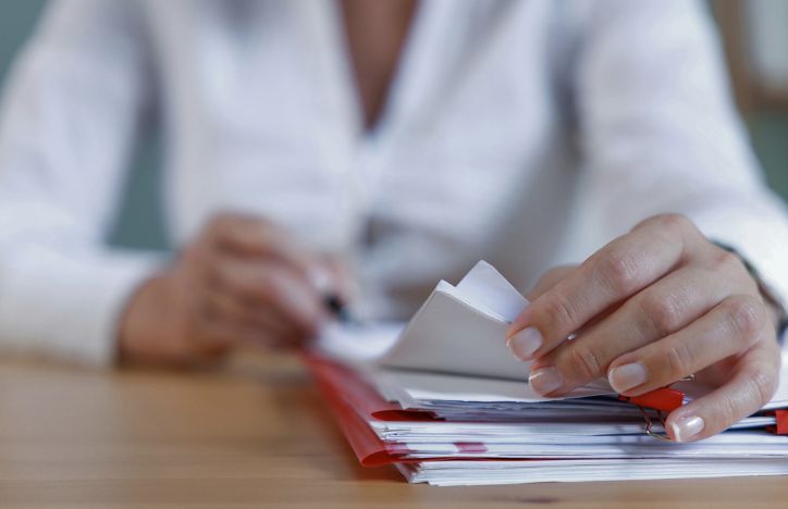 A Person Flicking Through A Pile Of Documents