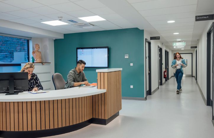 Patient Arriving At Reception For Doctors Appointment