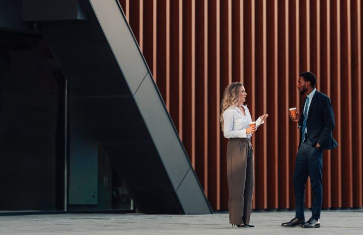 Two Employees Drinking Coffee Outside An Office