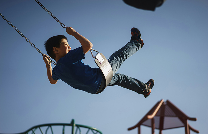Child Laughing While Swinging On A Swing