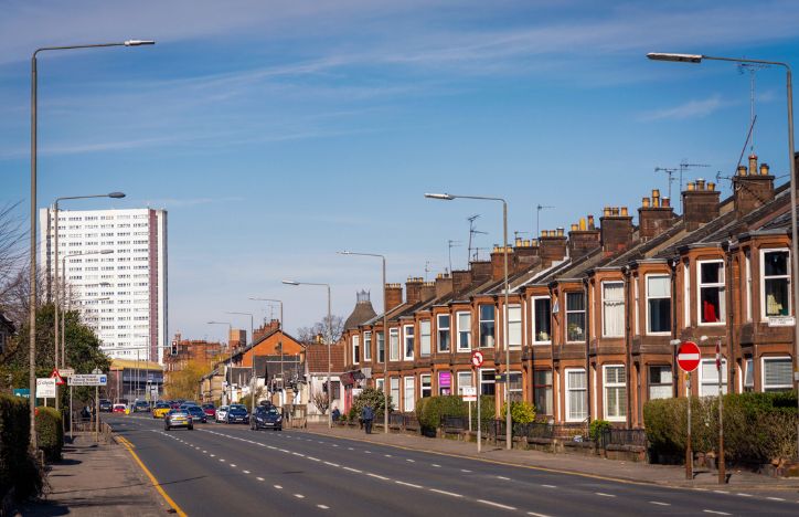 Row Of Terraced Housing And A Block Of Flats On A Busy Street