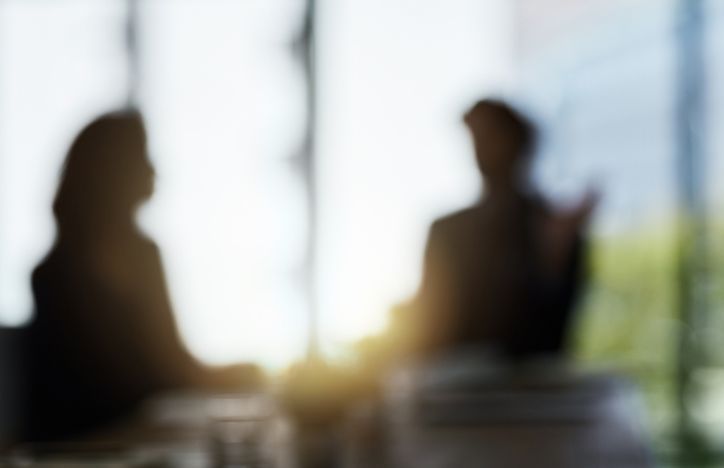 Blurred Meeting Between Two People In An Office Setting