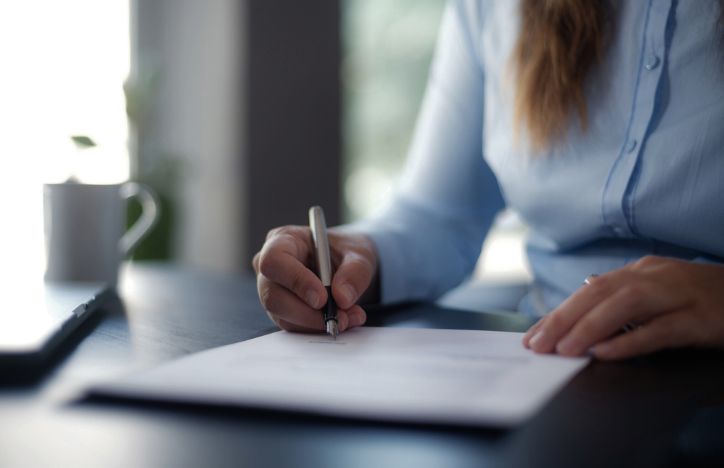 Person In Professional Attire Signing A Document