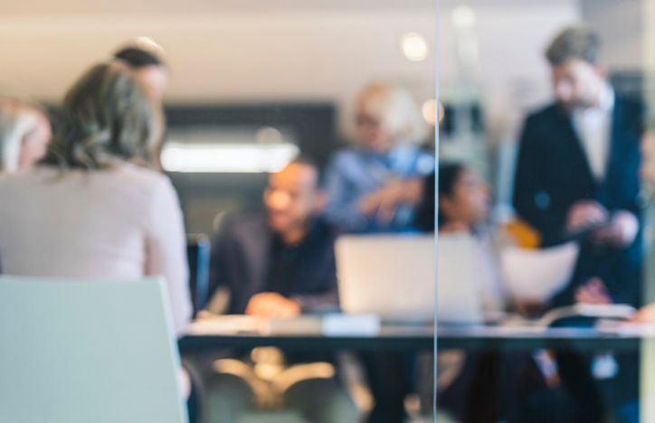View Through A Glass Door Of A Team's Meeting In An Office