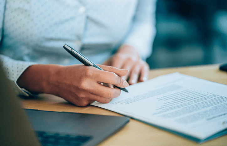 Woman Signing Contract And Laptop