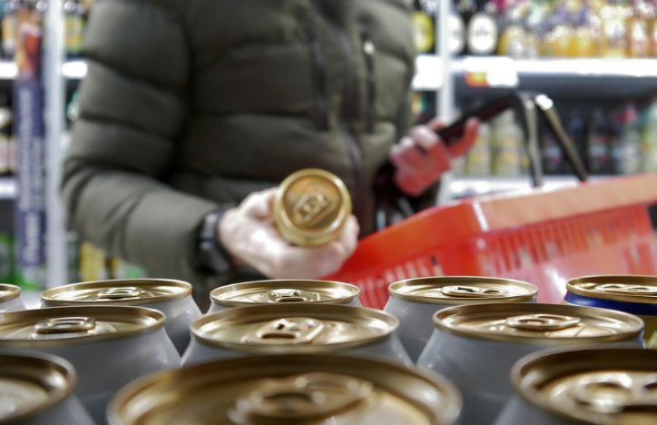 Man In Supermarket Picking Up A Can Of Drink