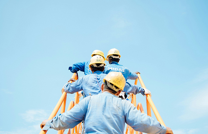 Construction Workers Walking Up Some Steps On Machinery