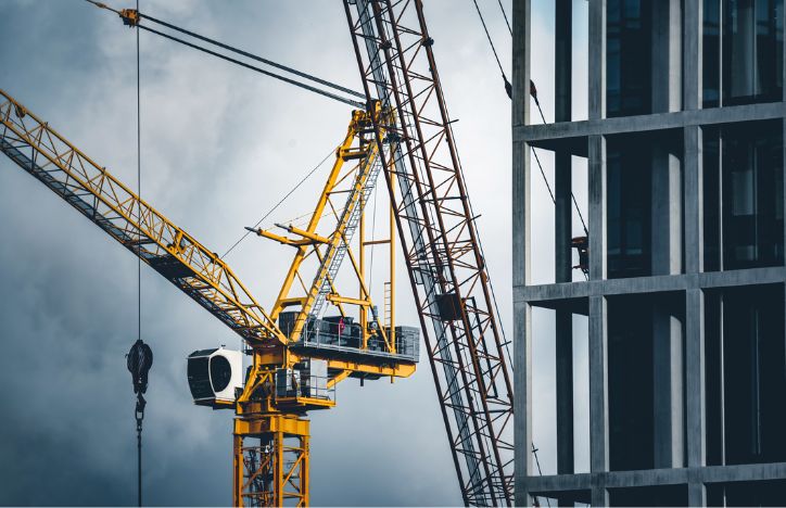 Cranes And A Building Under Construction On A Cloudy Day