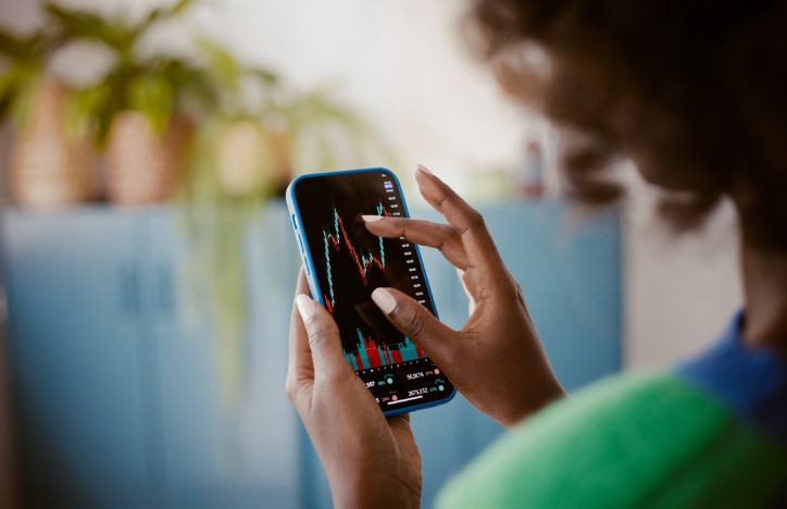 A Woman Inspecting Stock Charts On Her Phone