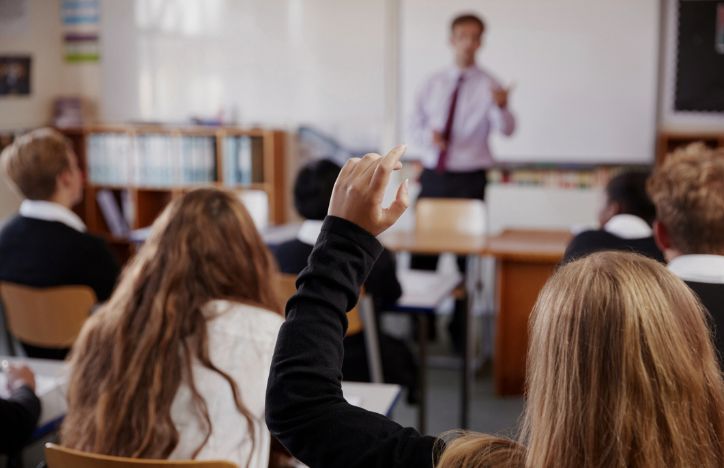 Pupil Raising Hand In Classroom