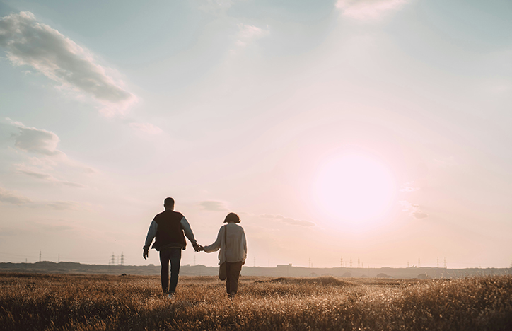 Couple Holding Hands In A Field