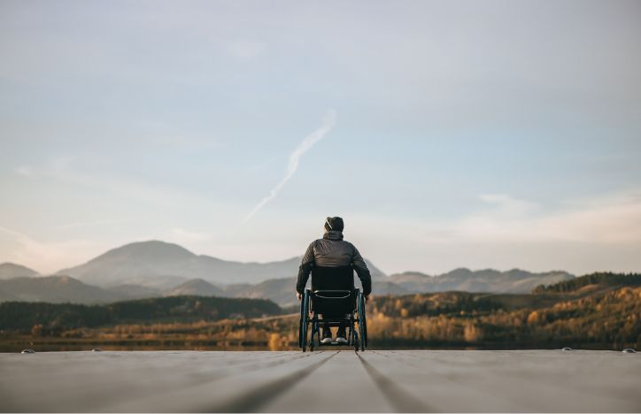Man In A Wheelchair Enjoying A Scenic View At Sunset