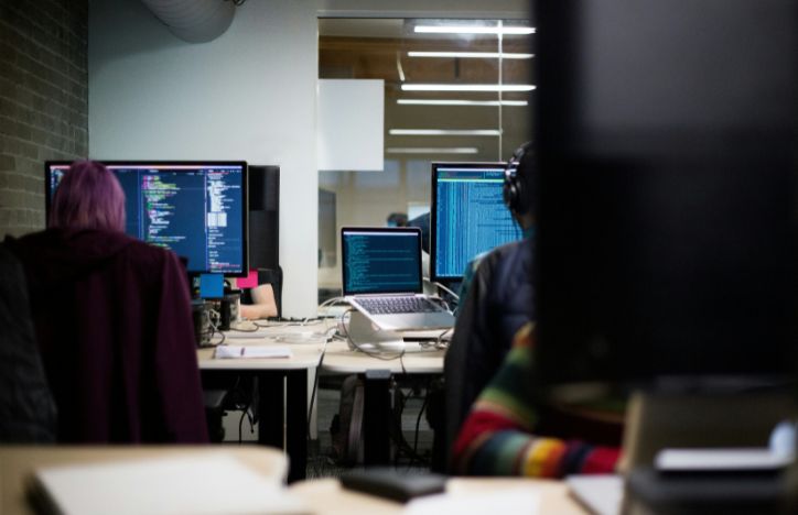 Close up of office desks and people working on code.jpg