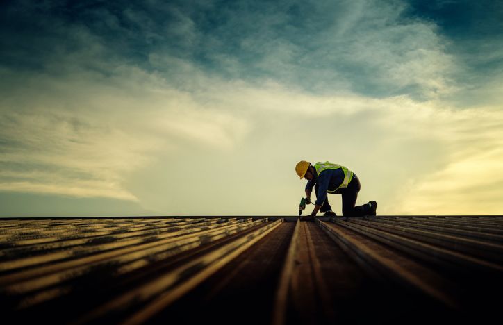 Worker Repairing Building Roof On A Construction Site