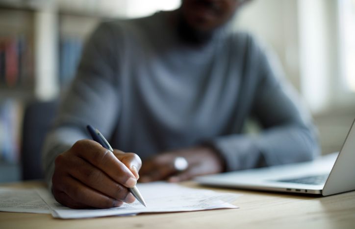 Man Working With Notes And Laptop